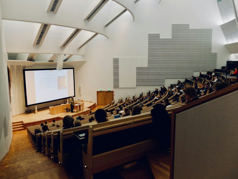 University lecture hall with students facing a projection screen
